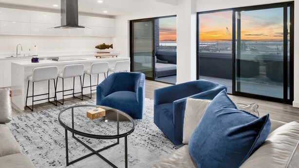 A modern apartment with a kitchen, dining area, and a balcony with a city view. - Bellingham Waterfront Penthouse • Wraparound Balcony, Downtown & Near WWU (Bellingham)