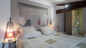 Ein Schlafzimmer mit Bett, Nachttischlampen, einem Spiegel und einem Kleiderschrank.