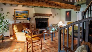Ein gemütliches Wohnzimmer mit Kamin, Holzmöbeln und einer Treppe.