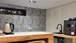 A kitchen with a wooden bar counter, a kettle, a sink, and a water dispenser. - Diafragma Livin (Nusa Dua)