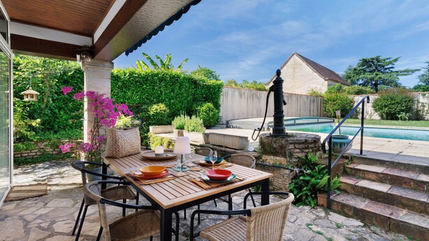 A patio with a table set for dining, a pool, and a stone staircase leading to a pool area. - Le Tsilaosa – Charm and Relaxation in the Heart of Périgord (Prigonrieux)