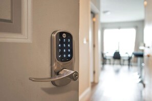 Ein Yale Smart Lock an einer Tür mit Schlüsselloch, ein Flur mit Essbereich im Hintergrund.