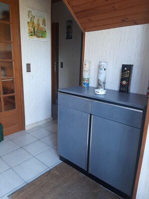Eine Küche mit einem grauen Schrank, einer Tür und einem kleinen Fenster.