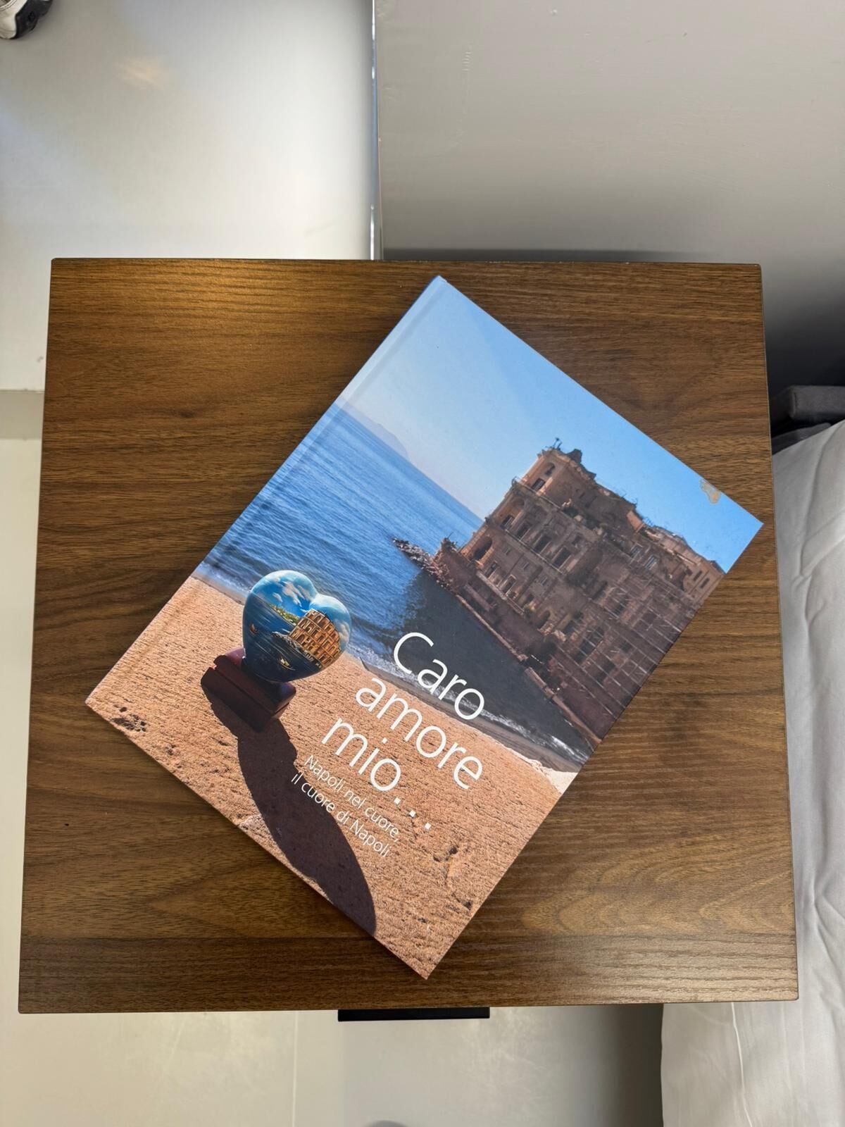A book titled 'Caro amore mio' on a wooden surface.