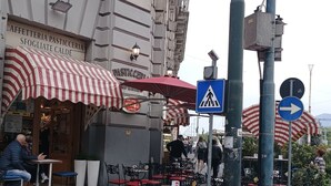 Outdoor seating with tables and chairs, a pedestrian crossing sign, and a directional sign. - Poerio Station Rooms & Apartment  (Naples)