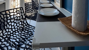A balcony with a dining table, chairs, and a view of buildings. - Poerio Station Rooms & Apartment  (Naples)