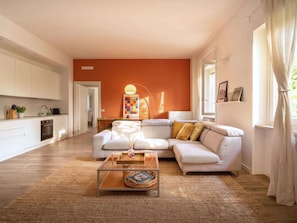 Ein modernes Wohnzimmer mit Sofa, Couchtisch und Küchenbereich.