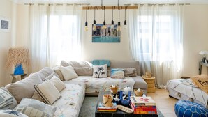 A living room with a sofa, coffee table, and a painting on the wall.
