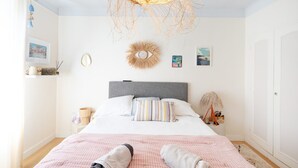 A bedroom with a bed, a bedside table, a lamp, and wall decorations.