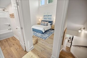 A bedroom with a bed, bedside tables, a nightstand, a window, and a view of the outside. - Enjoy our beautifully renovated Gulf-view condo in West PCB! (Panama City Beach)