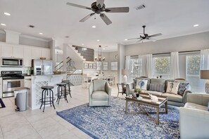 A spacious living area with a kitchen, a dining area, and a staircase leading to an upper level. - Princess of Monaco (Miramar Beach)