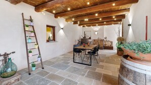 A rustic interior with exposed wooden beams, stone flooring, a wooden table with chairs, and potted plants. - Farmhouse 'Al Campo Del Nocciolo Agriturismo' with Mountain View, Wi-Fi and Air Conditioning (Busca)