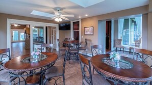 A dining area with a ceiling fan, a large window, and a view of the outside.