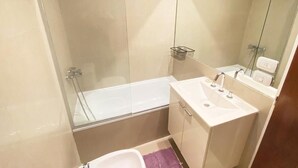 A bathroom with a bathtub, a sink, and a mirror. - Marais Recoleta (Buenos Aires)