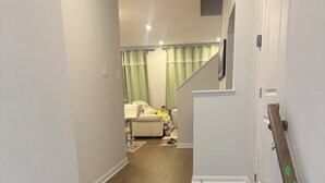A staircase leading to a living area with a couch and a rug. - Charming One‑Bedroom Getaway in a Peaceful Townhome Setting (Ottawa)