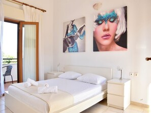 Ein Hotelzimmer mit einem Bett, zwei Nachttischen, einem Sessel und Bildern an der Wand.