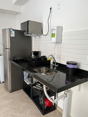 A modern kitchen with a stainless steel refrigerator, a coffee maker, a sink, and a water dispenser. - LK Centro 1 (Belo Horizonte)
