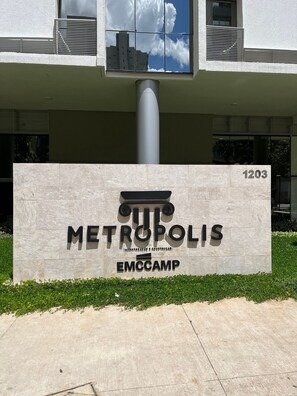 A building with a sign reading 'METROPOLIS EMCCAMP' and the number '1203' on a stone facade. - LK Centro 1 (Belo Horizonte)
