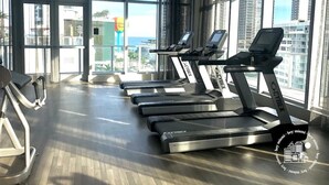 Ein Fitnessstudio mit Laufbändern, Ergometer und Rudergerät.