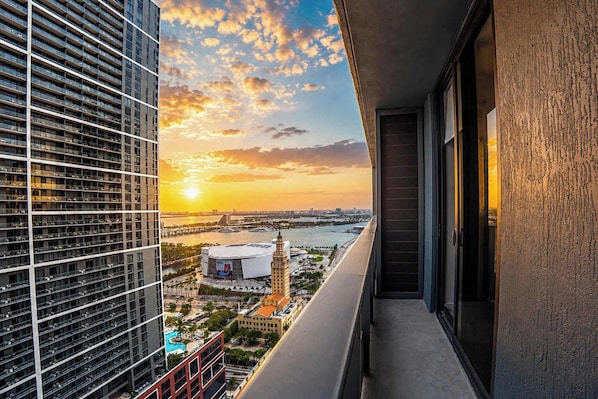 A high-rise building with a view of a cityscape, including a stadium and a river. - Luxury Downtown Miami Condo for 5 (Miami)