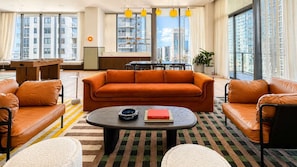 A modern living room with a sofa set, a coffee table, and a view of a cityscape through large windows. - Stylish 1BR in the Heart of Miami (Miami)