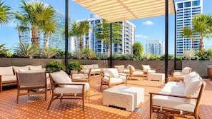 A rooftop lounge with outdoor seating, a patterned floor, and modern buildings in the background. - Stylish 1BR in the Heart of Miami (Miami)