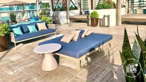 A rooftop lounge area with a sofa, lounge chairs, and a table. - 1 BR Sunset views Hollywood Beach (Hollywood)