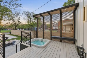 A rooftop deck with a hot tub, wooden slats, and a view of the neighborhood. - Linwood House | Rooftop, Hot Tub, Sleeps 15 | (Columbus)