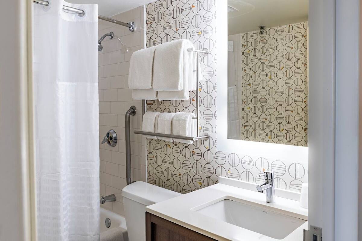 Une salle de bain équipée d’une douche, de toilettes et d’un lavabo, ainsi que d’un porte-serviettes et d’un miroir.