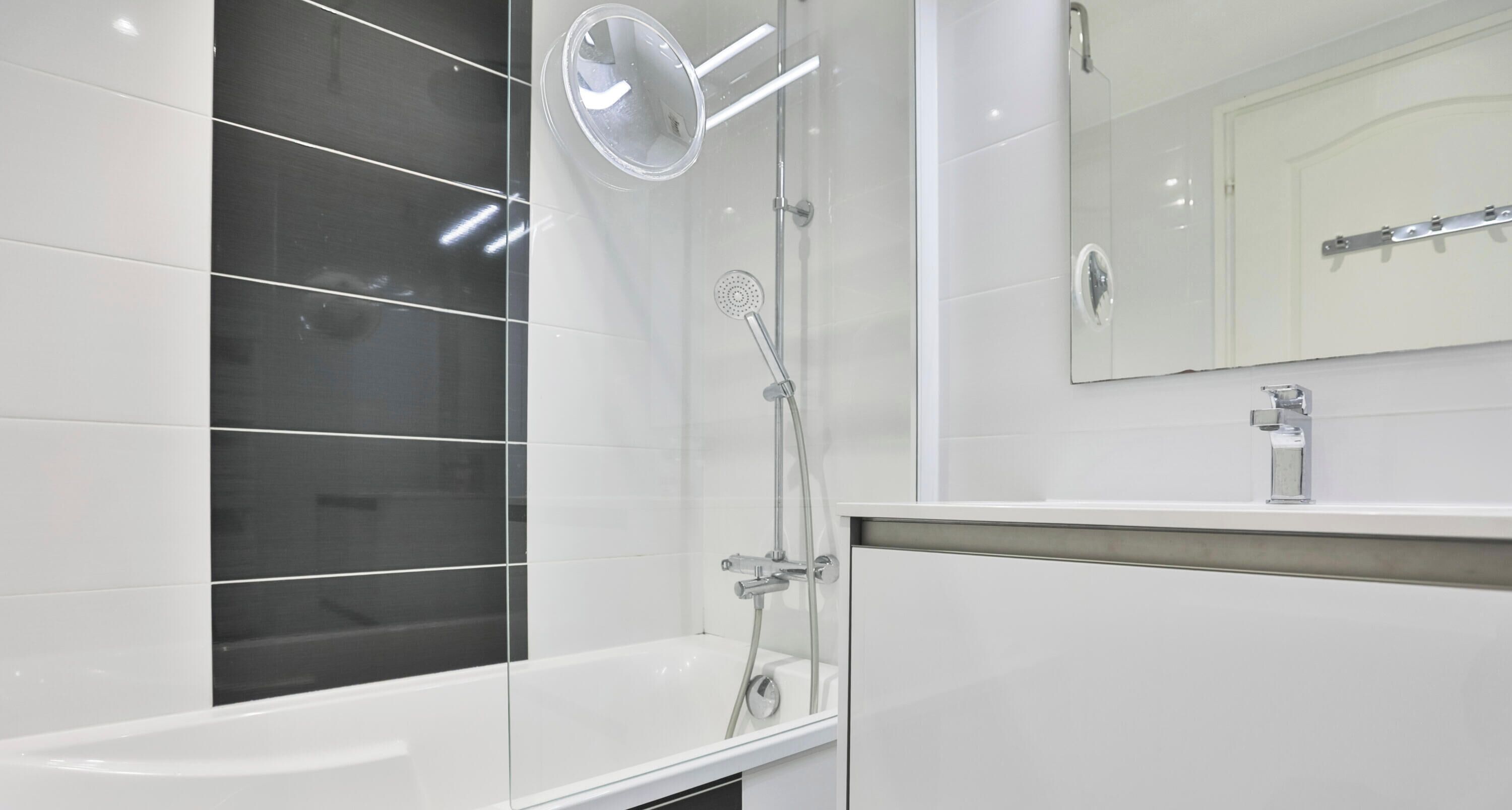 Une salle de bain moderne équipée d’une baignoire, d’une douche, d’un lavabo et d’un miroir.