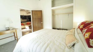 Ein Schlafzimmer mit einem Bett, einem Schreibtisch, einem Kleiderschrank und einem Schrank.