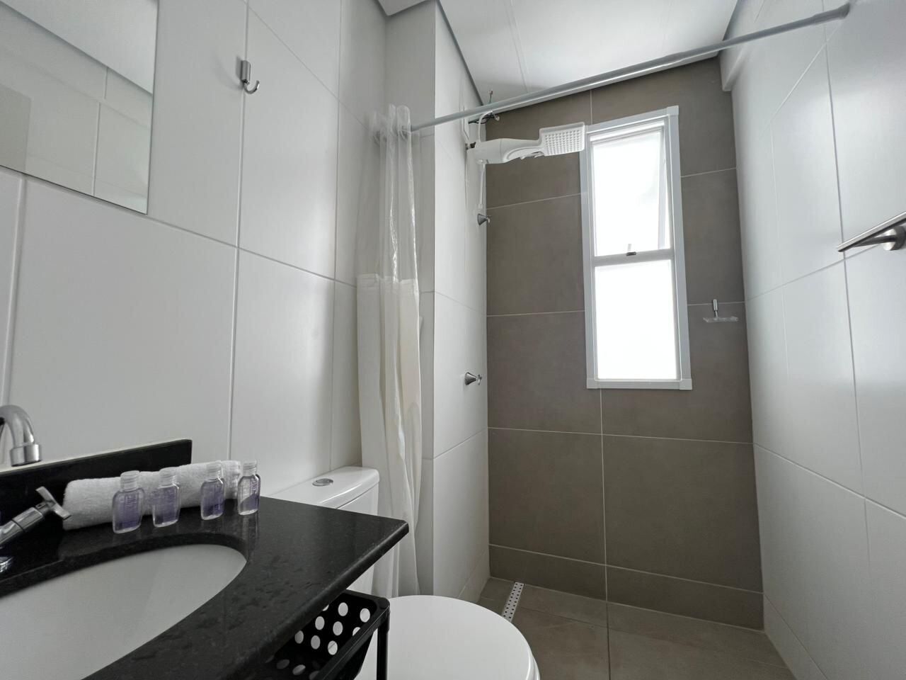 A bathroom with a shower, toilet, and sink.