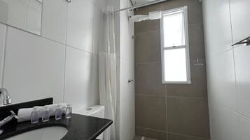 A bathroom with a shower, toilet, and sink.