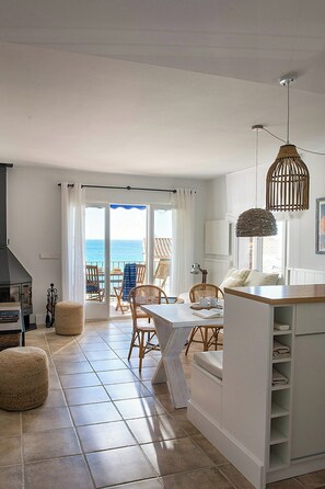 Eine moderne Küche mit Essbereich, Meerblick und Kamin.