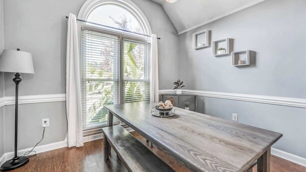 A dining area with a wooden table, bench, and a window with blinds. - Fenced Yard w/ Pool! Comfy & Convenient in Cordova (Memphis)