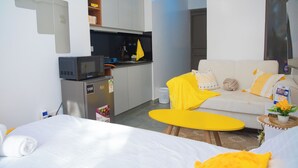 A hotel room with a bed, a sofa, a small kitchen area, and a dining table. - Charming apartment in pleasant Kiambu perfect for your getaway (Kiambu)