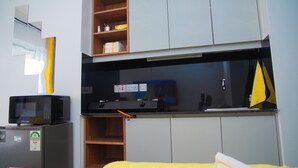 A compact kitchenette with a microwave, a small refrigerator, and a stove. - Charming apartment in pleasant Kiambu perfect for your getaway (Kiambu)