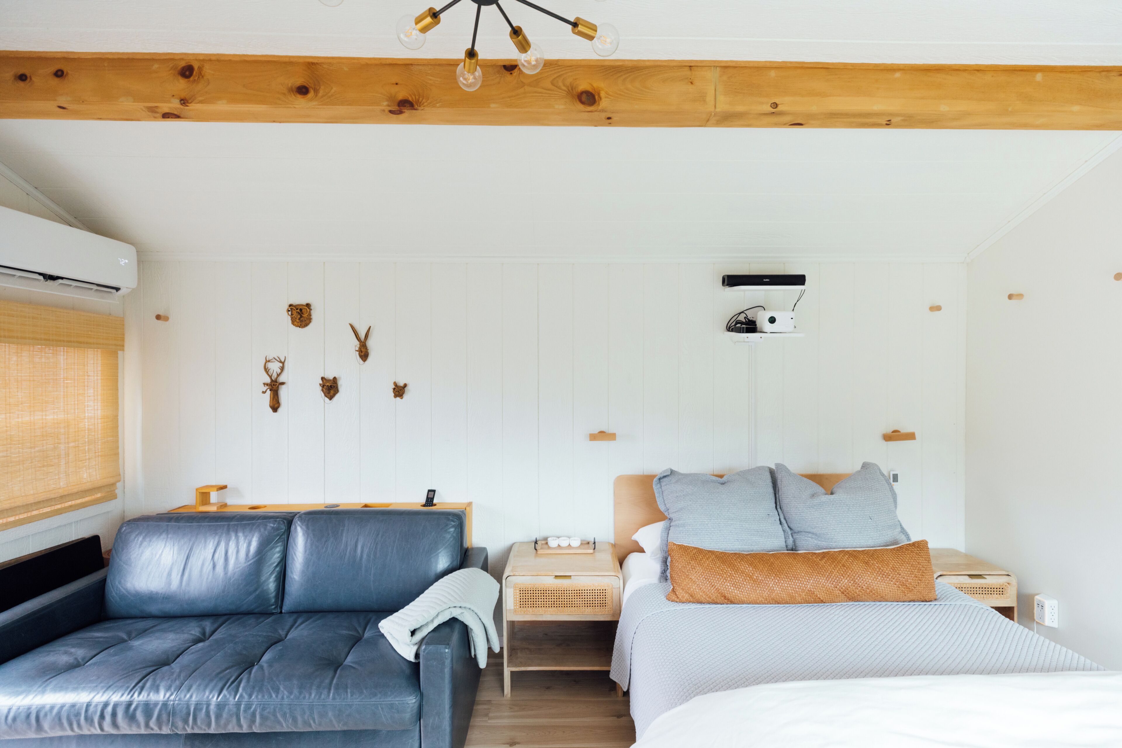 A bedroom with a bed, a sofa, a nightstand, and wall-mounted decor.
