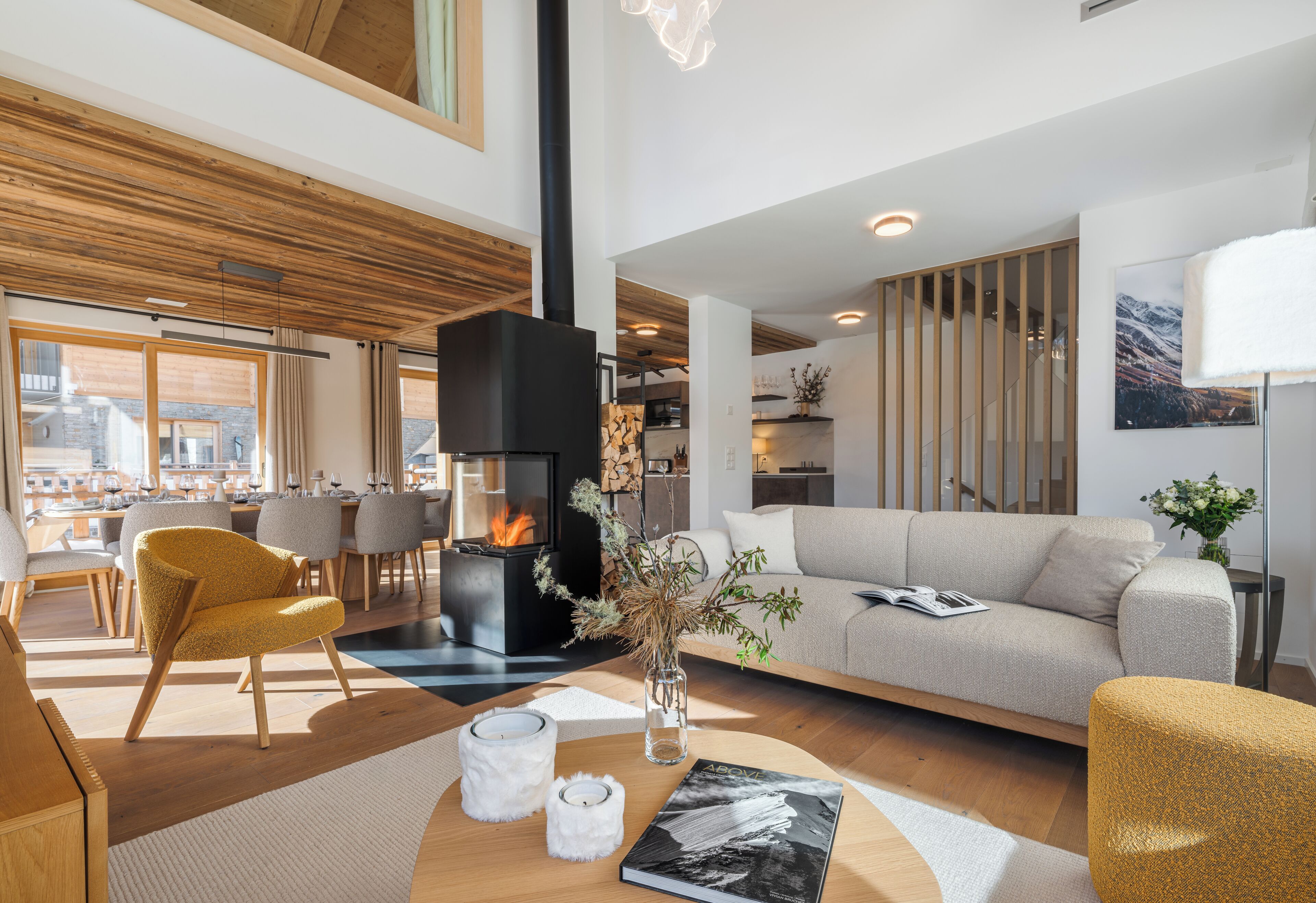 Un salon moderne avec une cheminée, un canapé, un coin repas et une vue sur la ville.