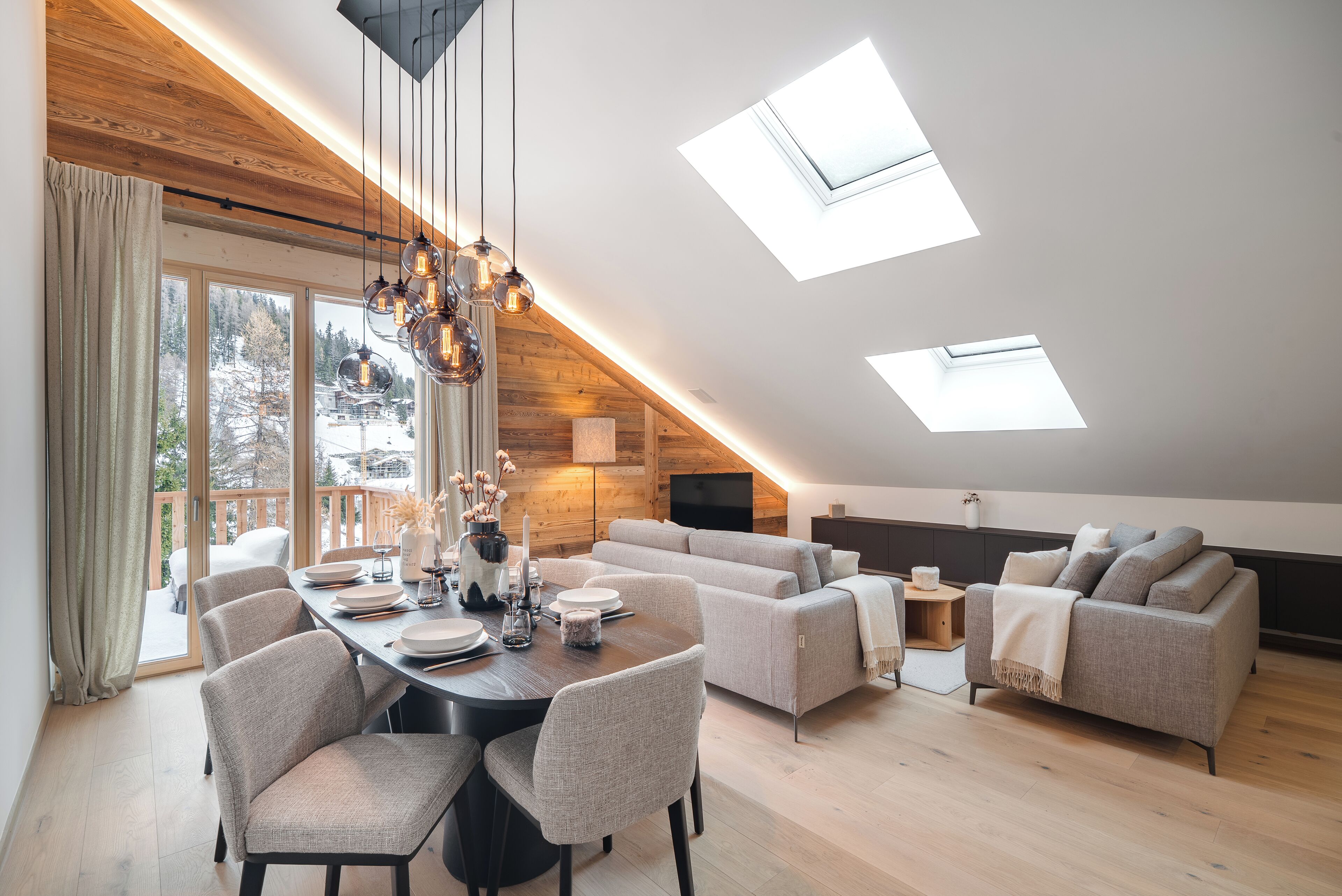 Un loft moderne comprenant un espace repas, des canapés et des fenêtres de toit.