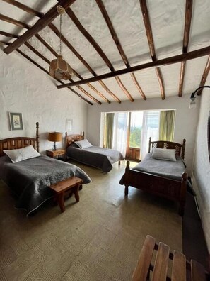 A room with two beds, a wooden bench, a hanging light fixture, and a window with curtains. - Hotel Puntalarga (Nobsa)