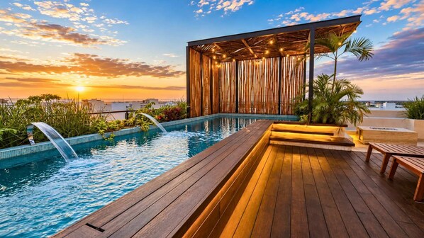 Ein Pool auf dem Dach mit einer Holzterrasse, einer überdachten Sitzgelegenheit und Blick auf den Sonnenuntergang.