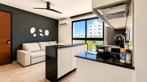 Eine moderne Küche mit schwarzem Arbeitsplatz, einem eingebauten Herd und einem Fenster mit Blick auf die Stadt.