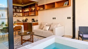 Ein modernes Wohnzimmer mit einer Couch, einem Couchtisch und einem Poolbereich.