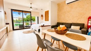 Ein modernes Hotelzimmer mit Balkon, Essbereich und Wohnbereich.