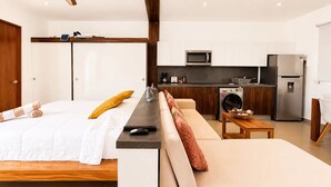 Ett modernt sovrum med en säng, ett sängbord och en soffa.