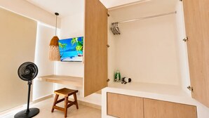 A modern bathroom with a wooden vanity, a towel rack, a fan, and a television displaying a tropical scene. - Cozy Studio steps from Coco Beach · Blanko Living (Playa del Carmen)