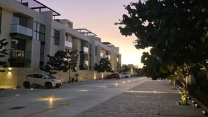 Un bâtiment moderne doté d’un toit plat, de grandes fenêtres et d’une allée pavée.