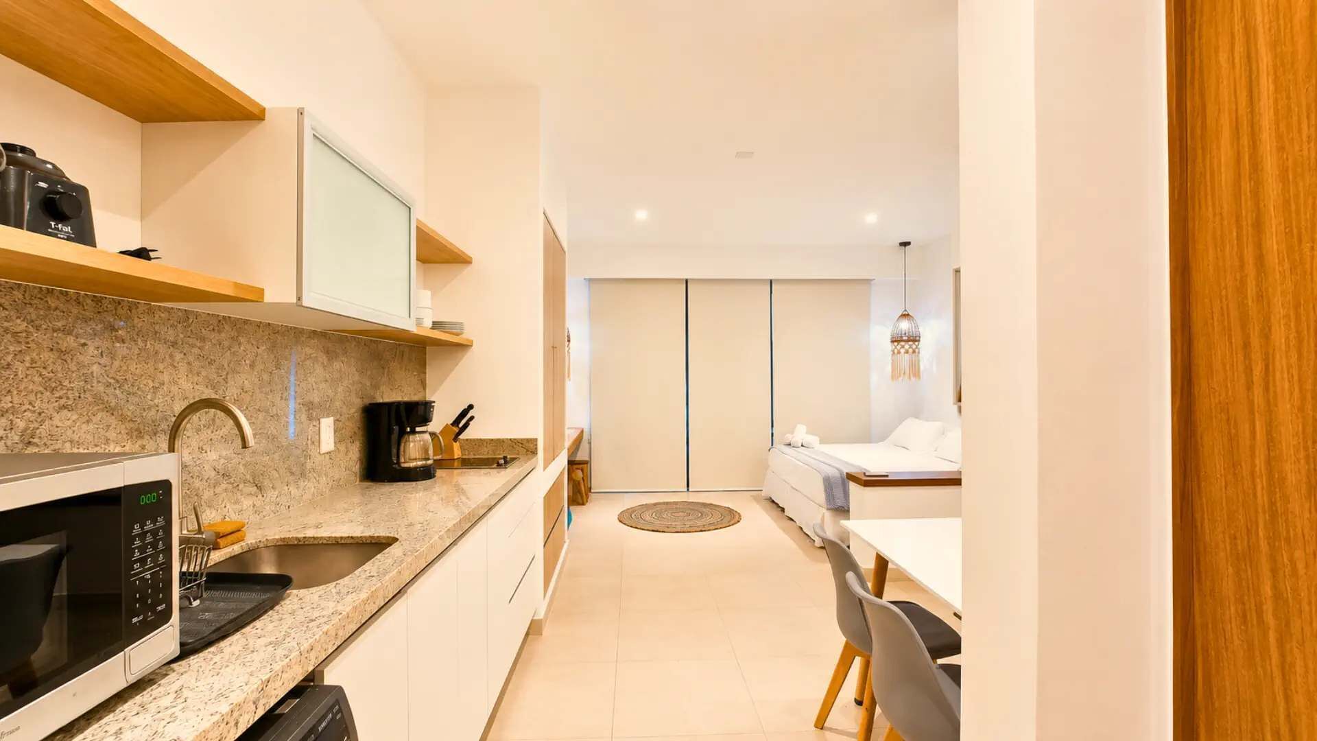 A compact kitchen with a microwave, coffee maker, and cabinets.