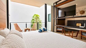 Ein modernes Hotelzimmer mit einem gro ßen Bett, einem Balkon mit Sitzgelegenheiten, einem Fernseher und einer Pflanze.